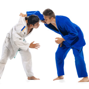 Fotografia che ritrae due judoka che si affrontano su sfondo bianco.