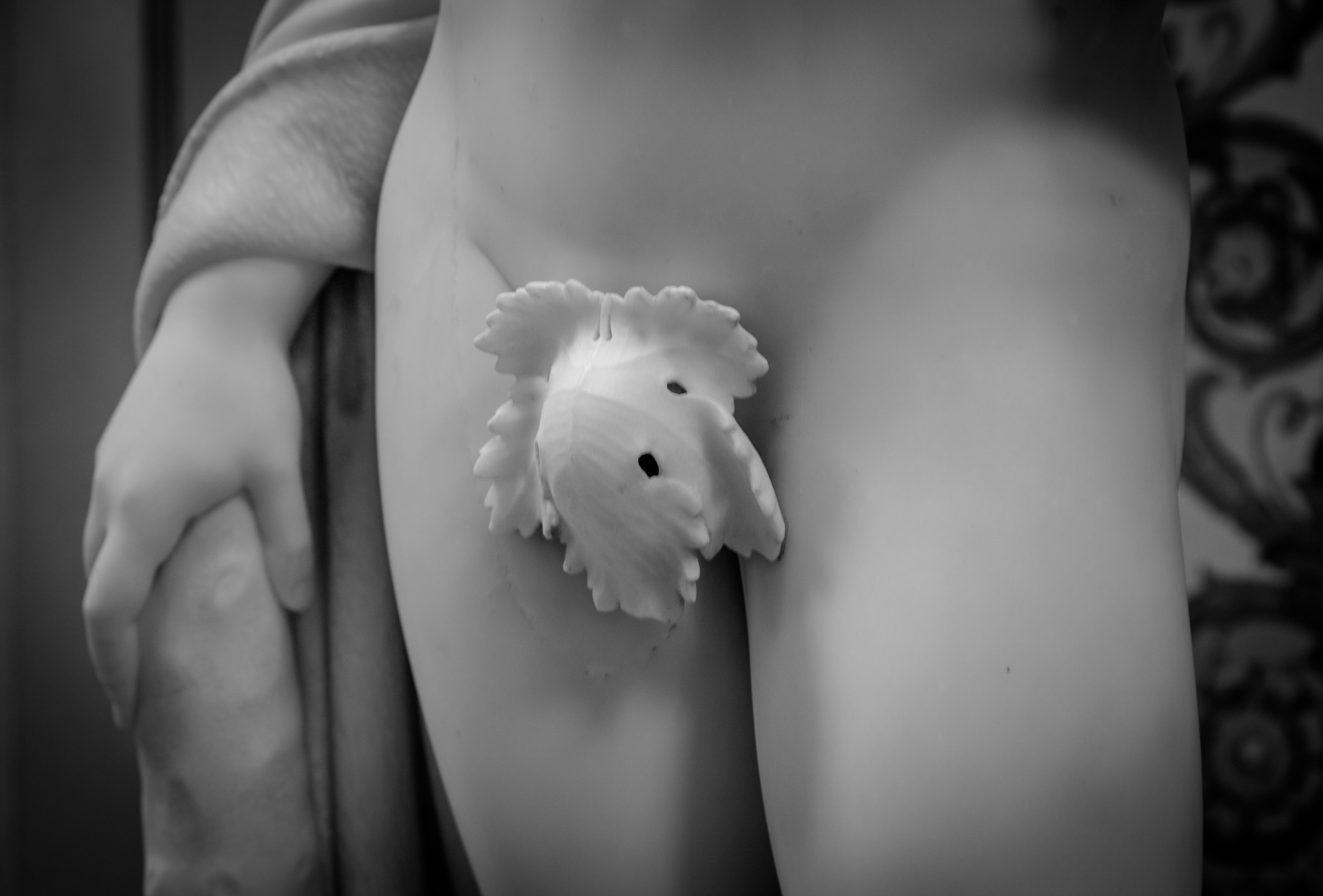 Close-up of a classic naked female statue with her pubis covered with a leaf.