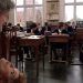 Un fotogramma da una scena del film “Il senso della vita” dei Monty Python in cui un rigido, serissimo professore di college inglese illustra l’atto sessuale a una classe di alunni un po’ perplessi mettendolo in pratica con estremo distacco e dovizia di istruzioni insieme a una collega.