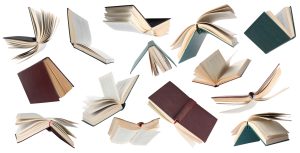Una composizione fotografica che mostra tanti libri aperti che paiono svolazzare su uno sfondo bianco.