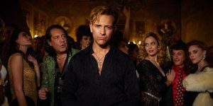 Una foto di scena a colori che ritrae il cast della serie "Supersex" nel contesto - parrebbe - di una festa in una casa di lusso.