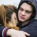 Una foto che ritrae un ragazzo triste che abbraccia una ragazza.
