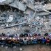 Una foto di Mahmud Hams per AFP che ritrae dall'alto una lunga tavolata con tante persone, uomini, ragazzi e bambini, sedute a mangiare, tra le macerie di Gaza.