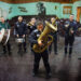 Una foto a colori, in formato orizzontale, che ritrae una banda musicale formata da sette carcerati, in piedi con vari strumenti davanti a una platea di sedie vuote. In primo piano c'è un uomo con un trombone, gli altri sei sono disposti in fila alle sue spalle.