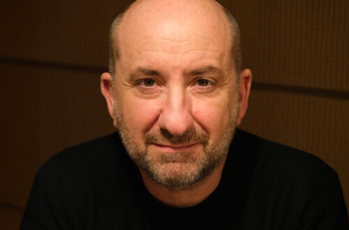 Un ritratto fotografico, in formato orizzontale, di Antonio Albanese, in primo piano.