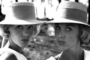 Una foto in bianco e nero che ritrae le gemelle Kessler, una di fianco all'altra, mentre ballano e cantano.