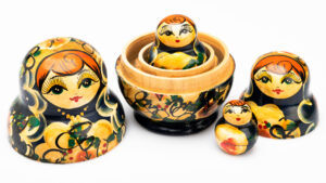 Una foto orizzontale, a colori, che ritrae una matrioska, una bambola russa di legno dipinto che contiene un'altra bambola identica ma più piccola, che ne contiene un'altra ancor più piccola, e così via.