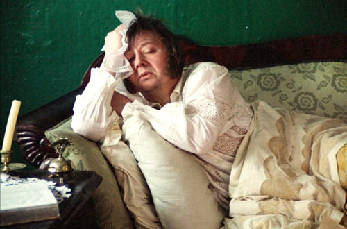 Un fotogramma dal film “Oblomov” di Nikita Michalkov che ritrae l'omonimo protagonista, un nobile decadente e accidioso, sdraiato sul fianco destro su un divano, in pigiama, sonnecchiante.