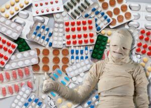 Un fotomontaggio con una persona completamente avvolta in bende davanti a una gran quantità di pillole medicinali.
