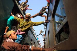 Una foto a colori che ritrae delle persone che saltano da un treno a un altro.