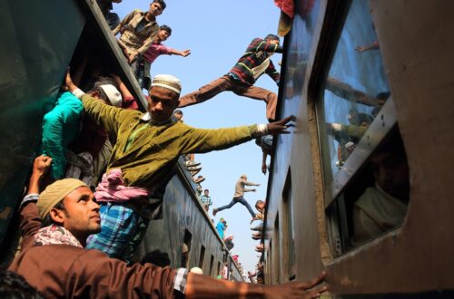 Una foto a colori che ritrae delle persone che saltano da un treno a un altro.